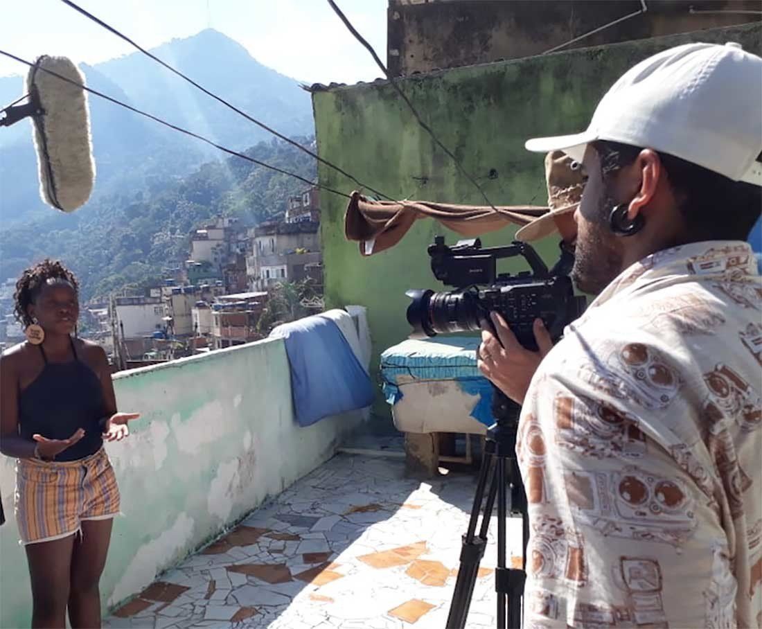 A man is holding a camera in front of a woman