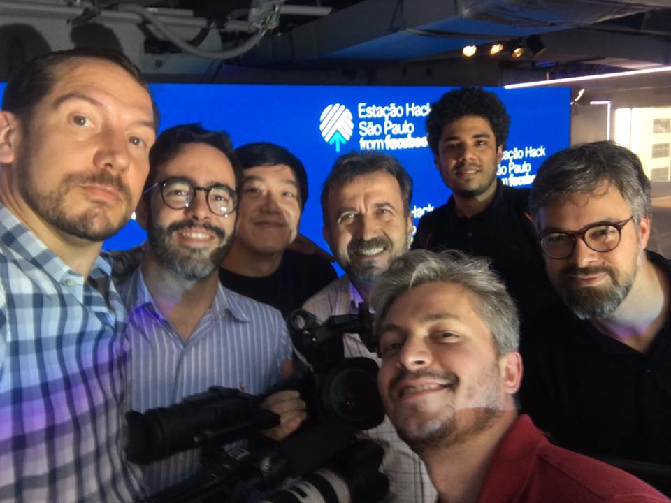 A group of men are posing for a picture in front of a sign that says estadio hack