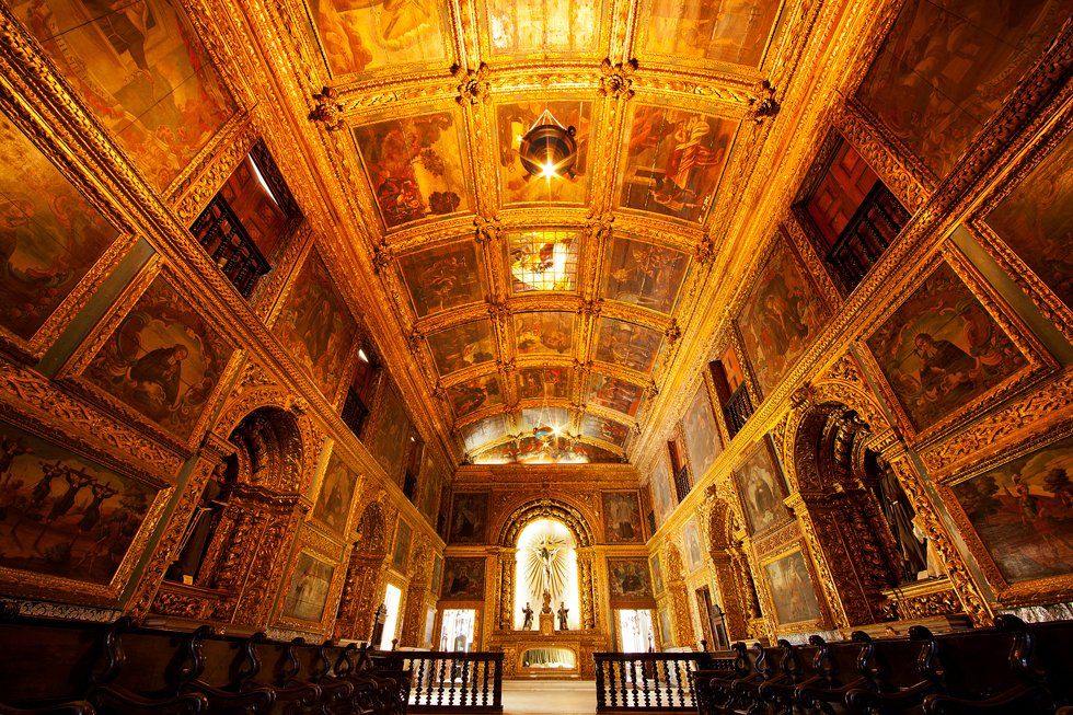 L'intérieur d'une église plus légère avec un autel à l'arrière et un plafond décoré
