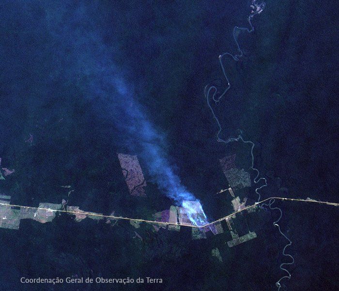 A satelite photograph that displays road and a fire in the Amazon Rainforest