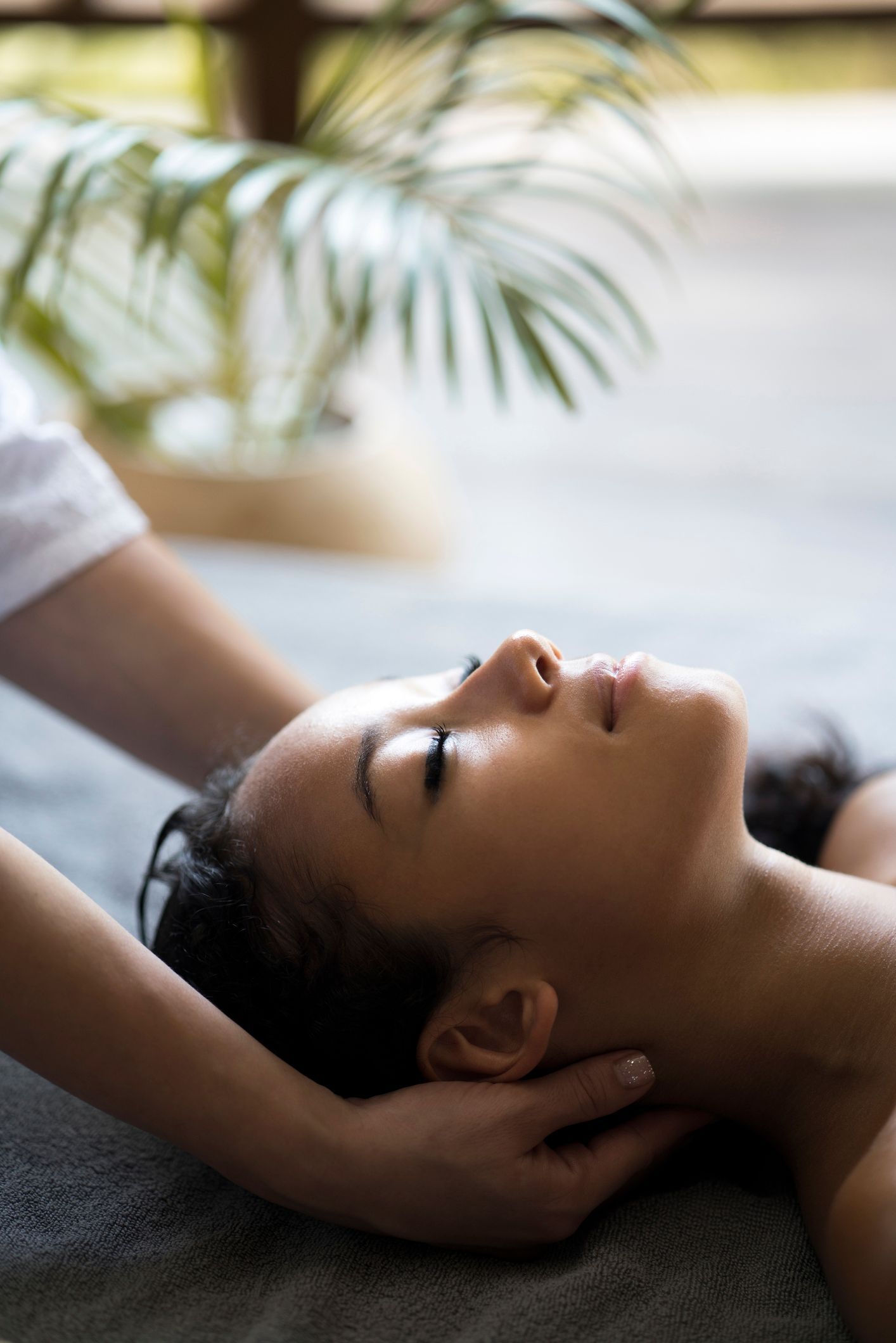 A woman is getting a head massage at a spa.