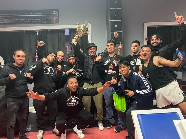 A group of men are posing for a picture and one of them is holding a trophy.