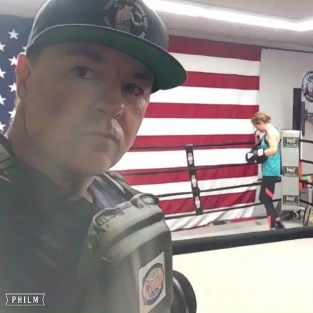 A man taking a selfie in front of an american flag