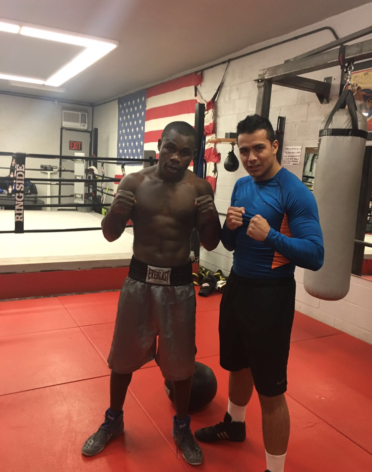 Two men are posing for a picture in a boxing ring