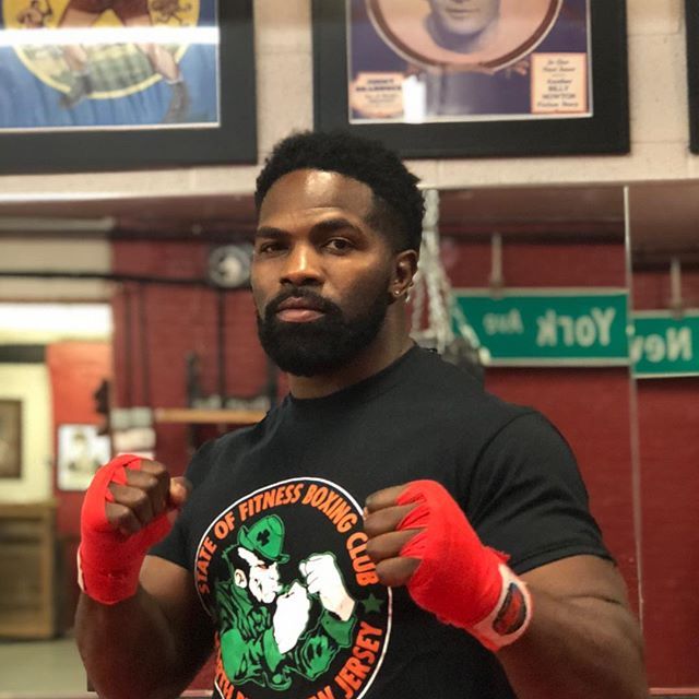 A man wearing a black shirt that says state of fitness boxing club