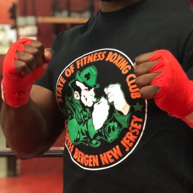 A man wearing a black shirt that says state of fitness boxing club