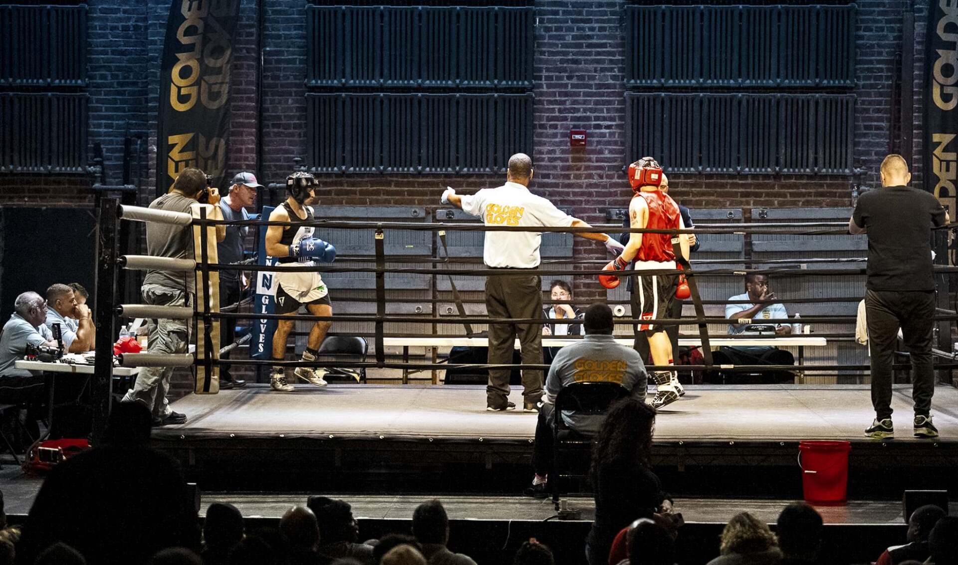 A referee in a boxing ring with the number 12 on his shirt