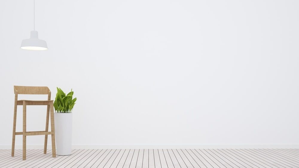 A White Painted Wall With A Chair, Plant And A Lamp — Painting service in Yeppoon, QLD