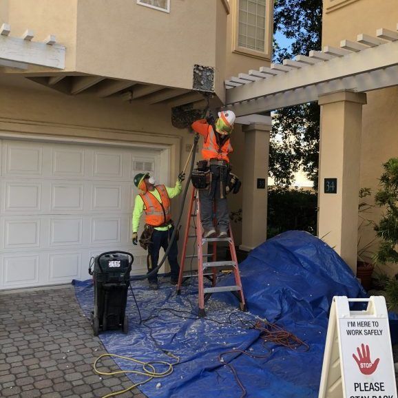 Worker on a ladder leaning against a roof