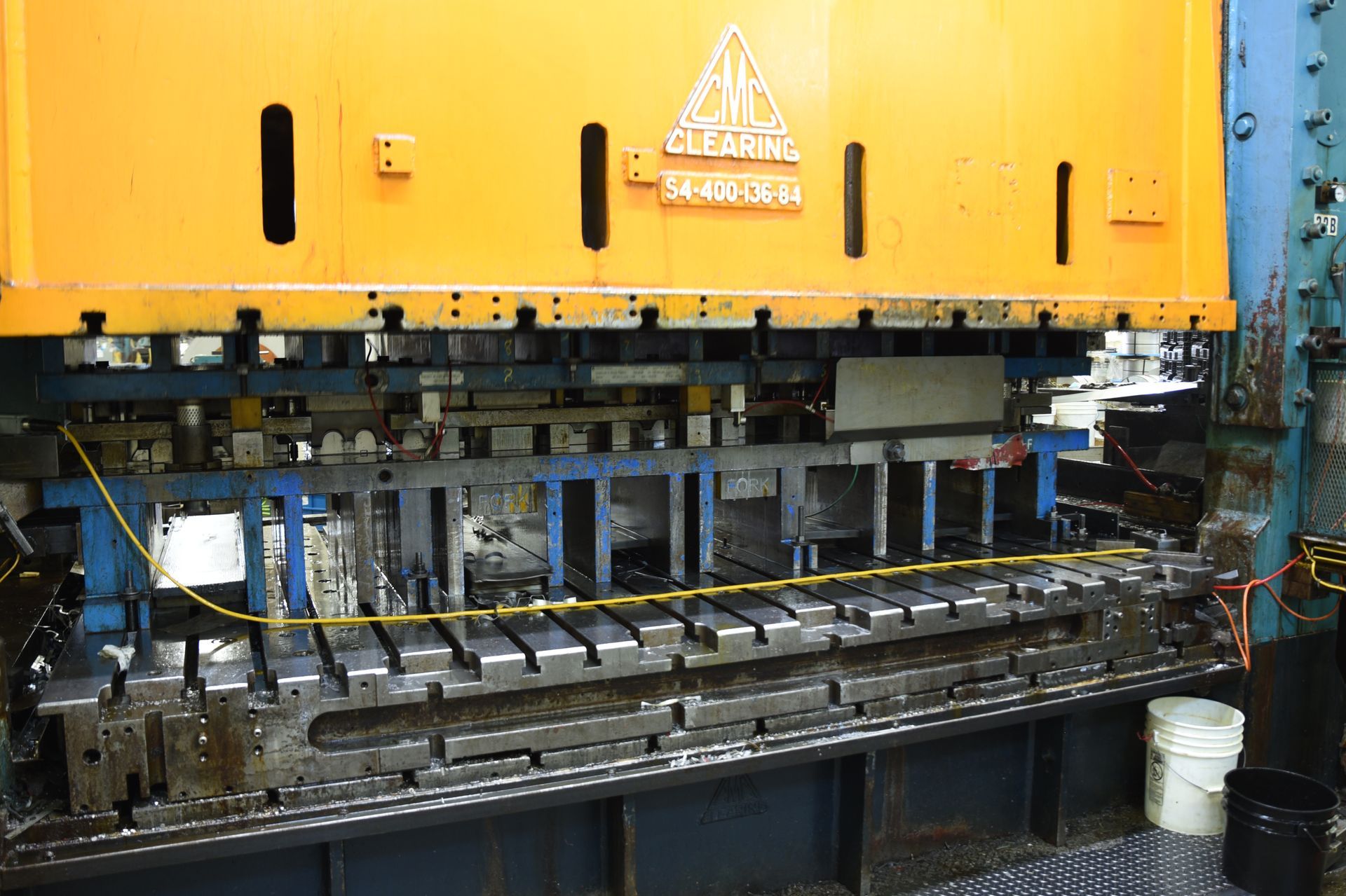 A large yellow machine is sitting on a table in a factory.