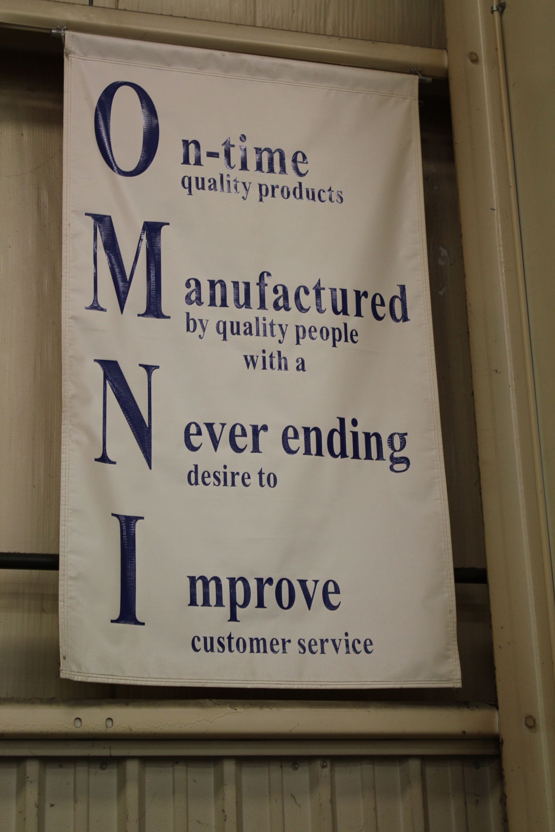 A sign that says on-time manufactured by quality people with a desire to improve customer service