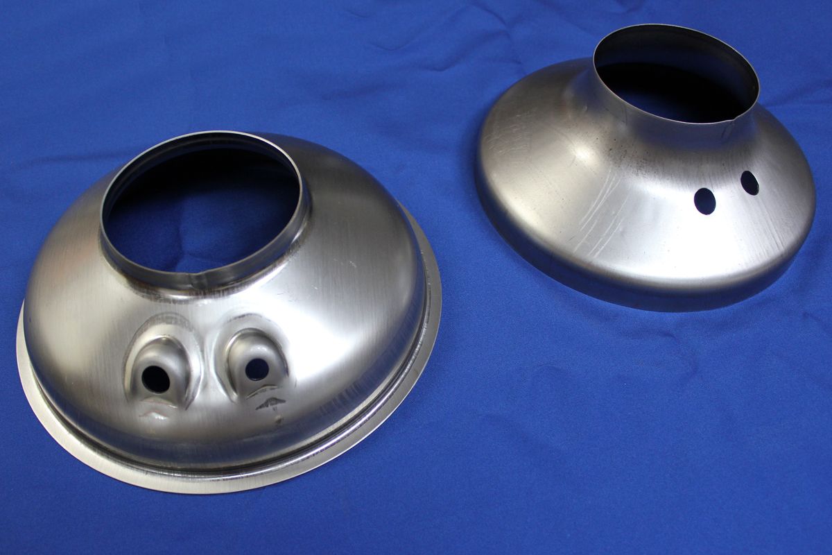 Two metal plates with holes in them on a blue surface