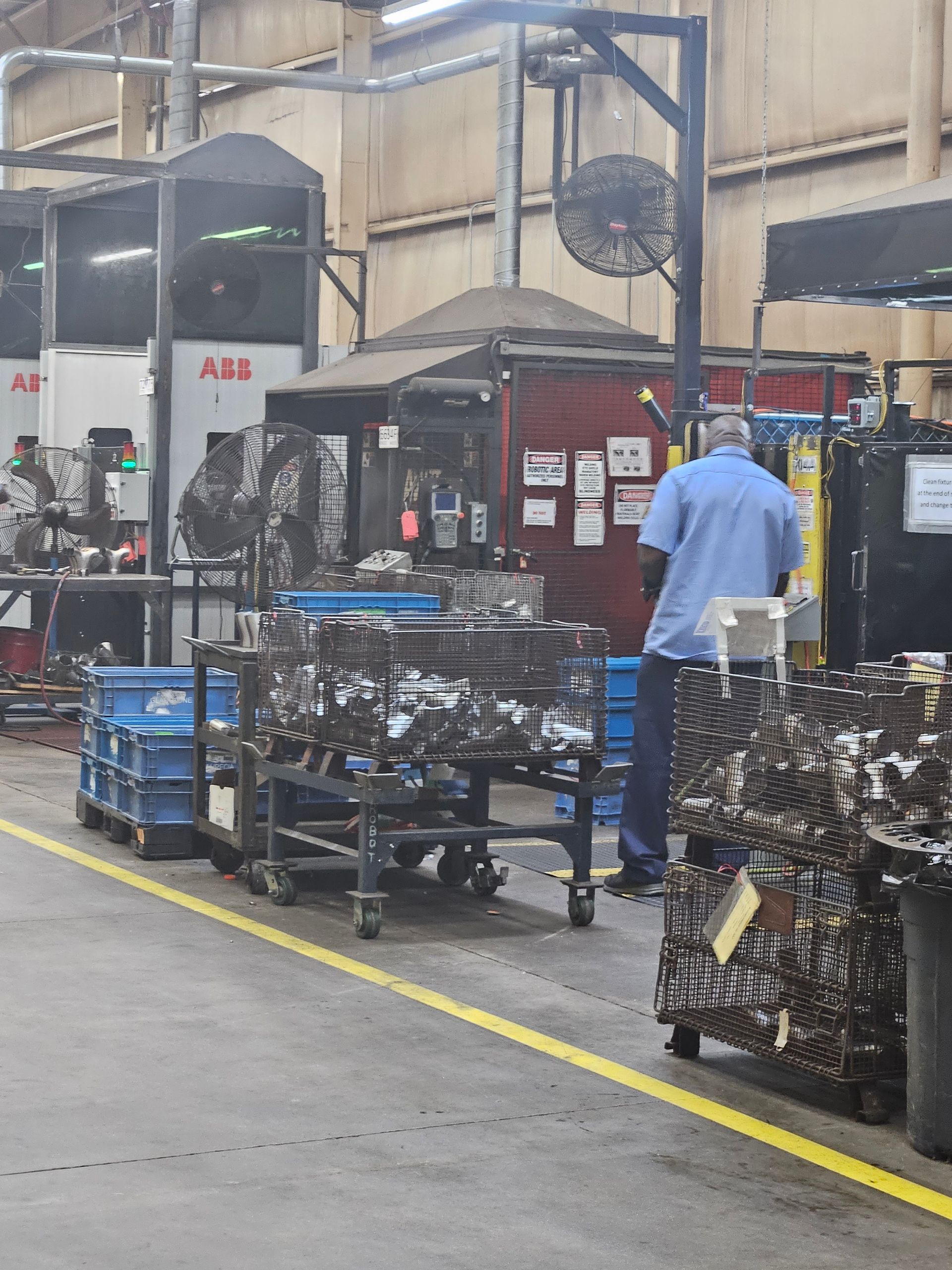 A man in a blue shirt is working in a factory