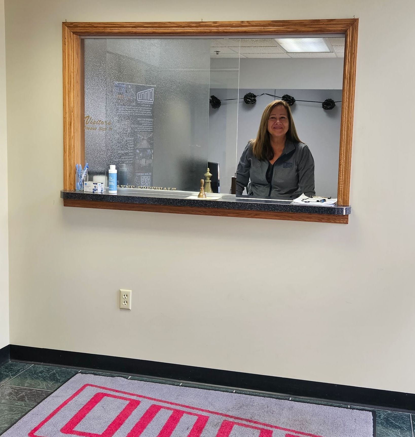 A woman is standing in front of a window in a dental office