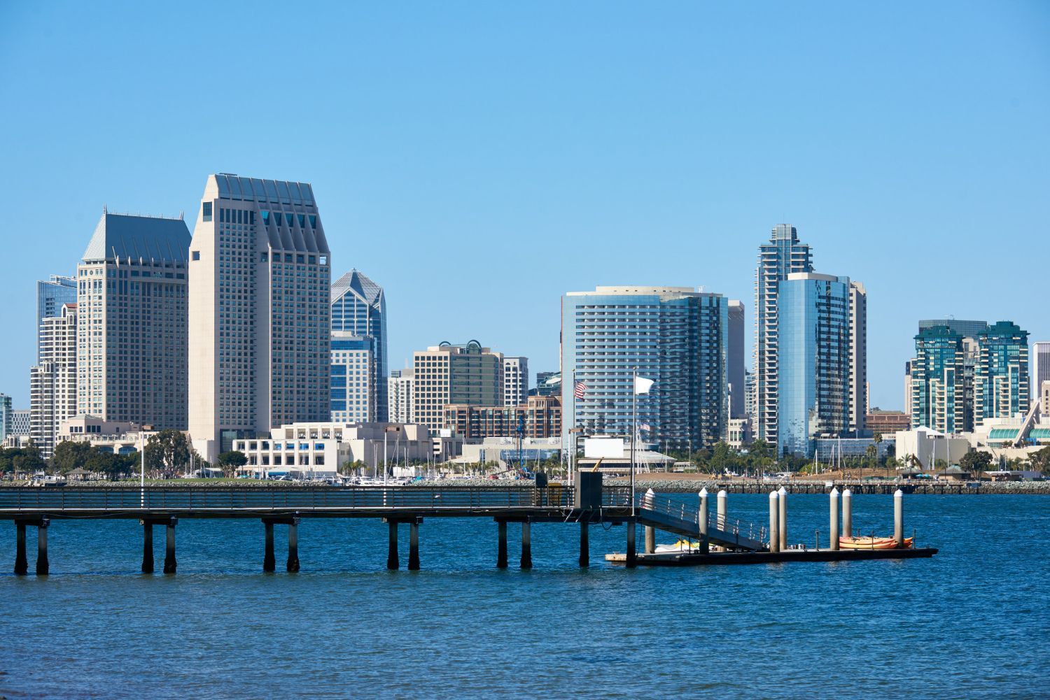 San Diego skyline with waterfront pier on a clear, sunny day.