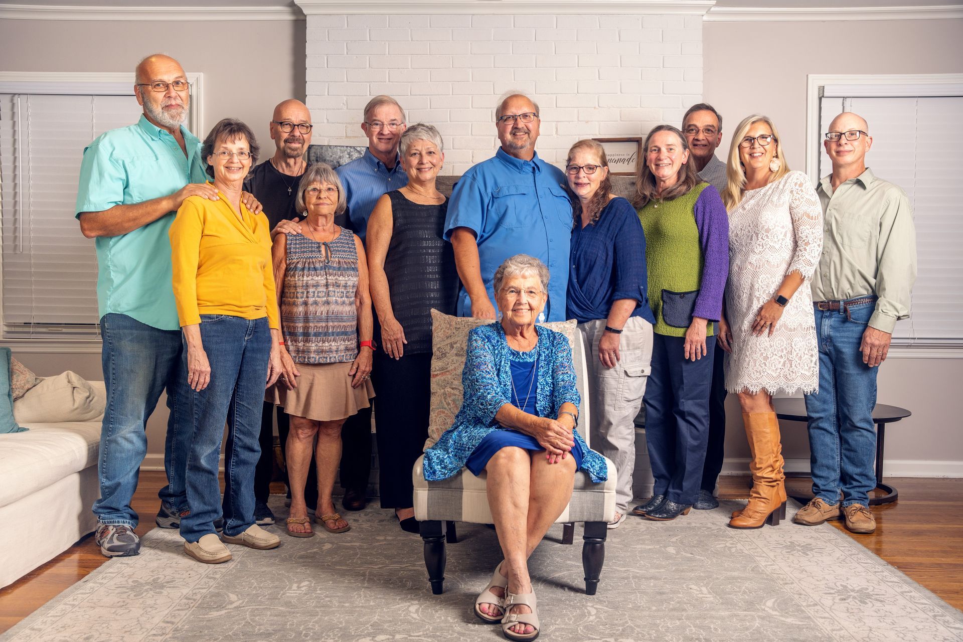 A large family is posing for a picture in a living room.