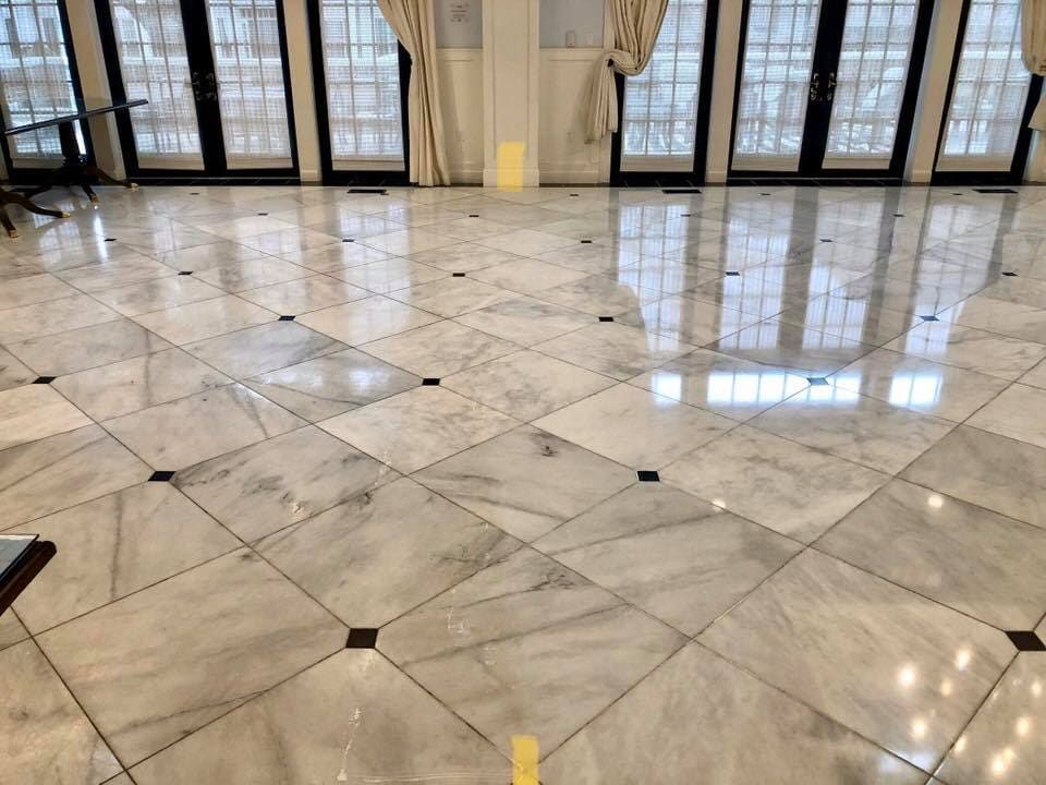A large room with a marble floor and lots of windows.