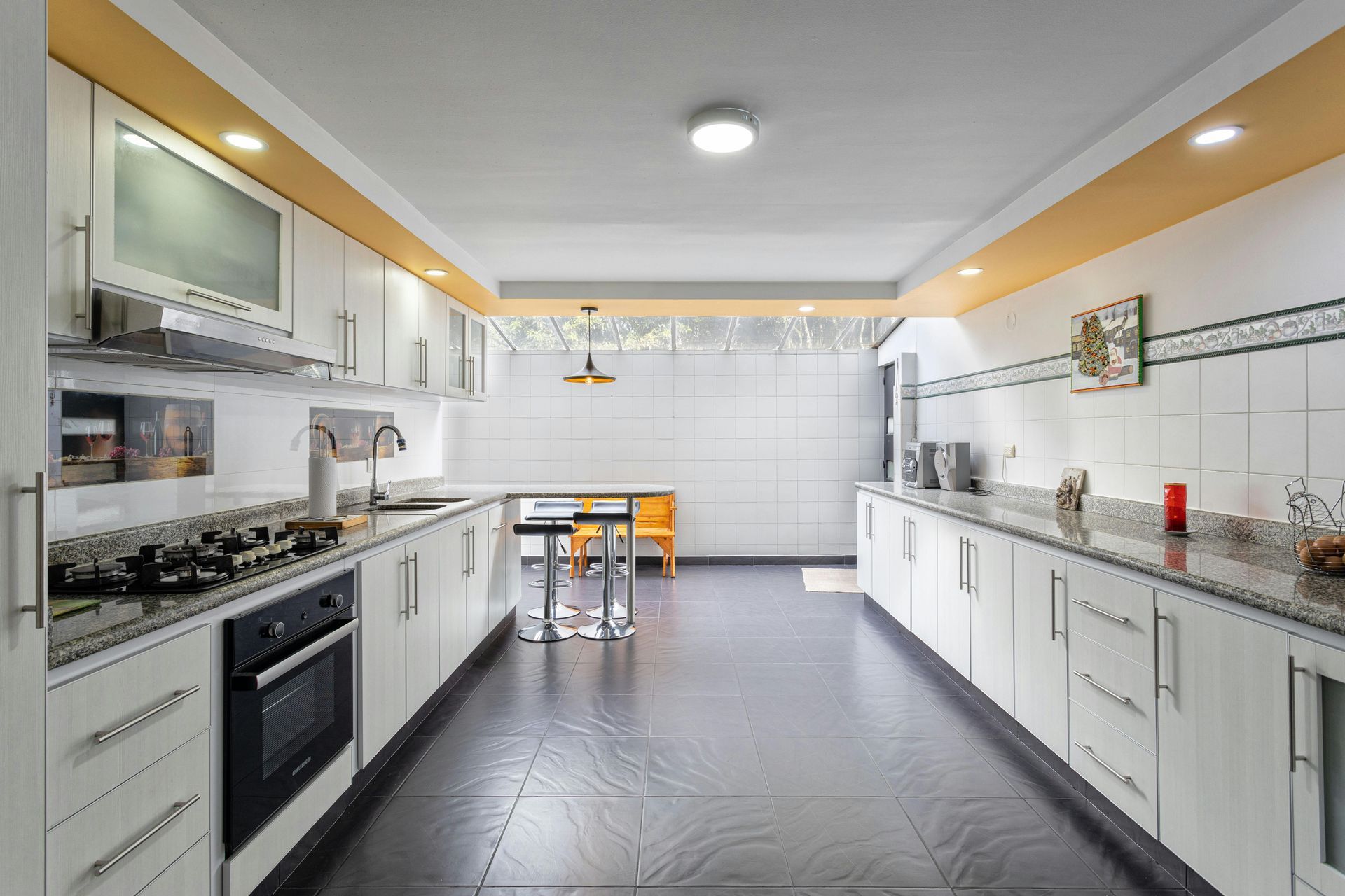 A kitchen with white cabinets and black tile floors