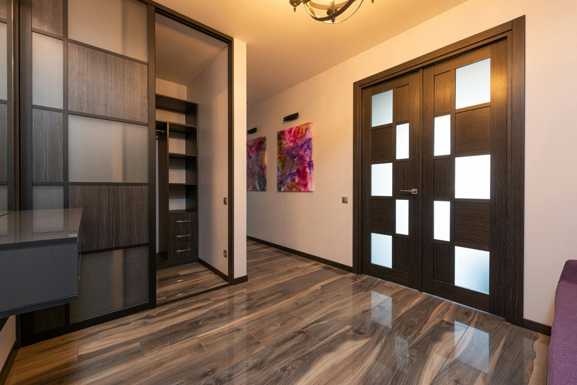 A hallway with a sliding glass door and a walk in closet.