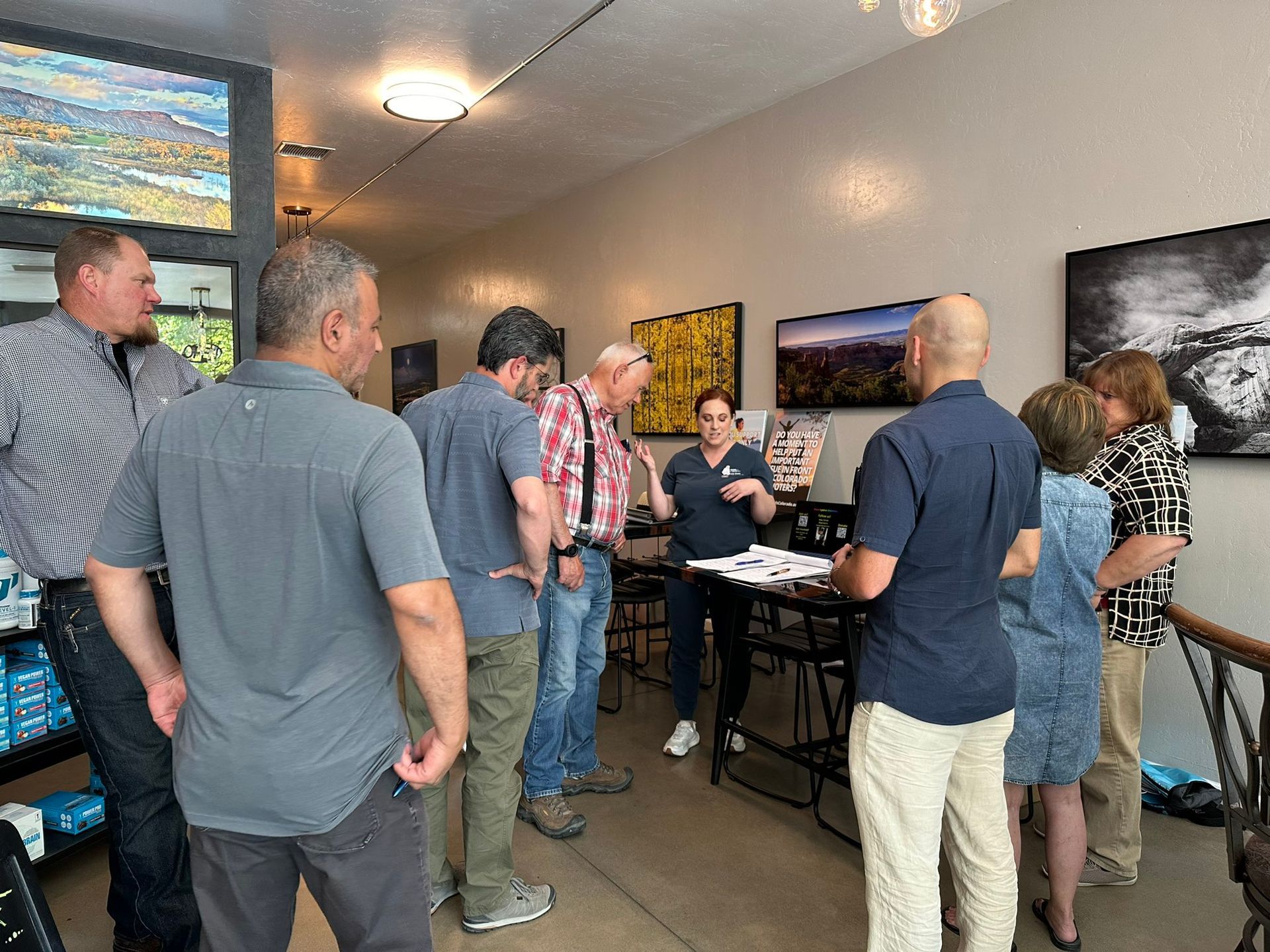 A group of people are standing around a table in a room.
