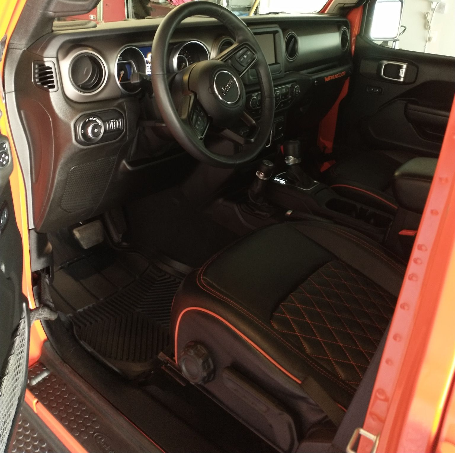 A vehicles interior thats black leather with a large screen display