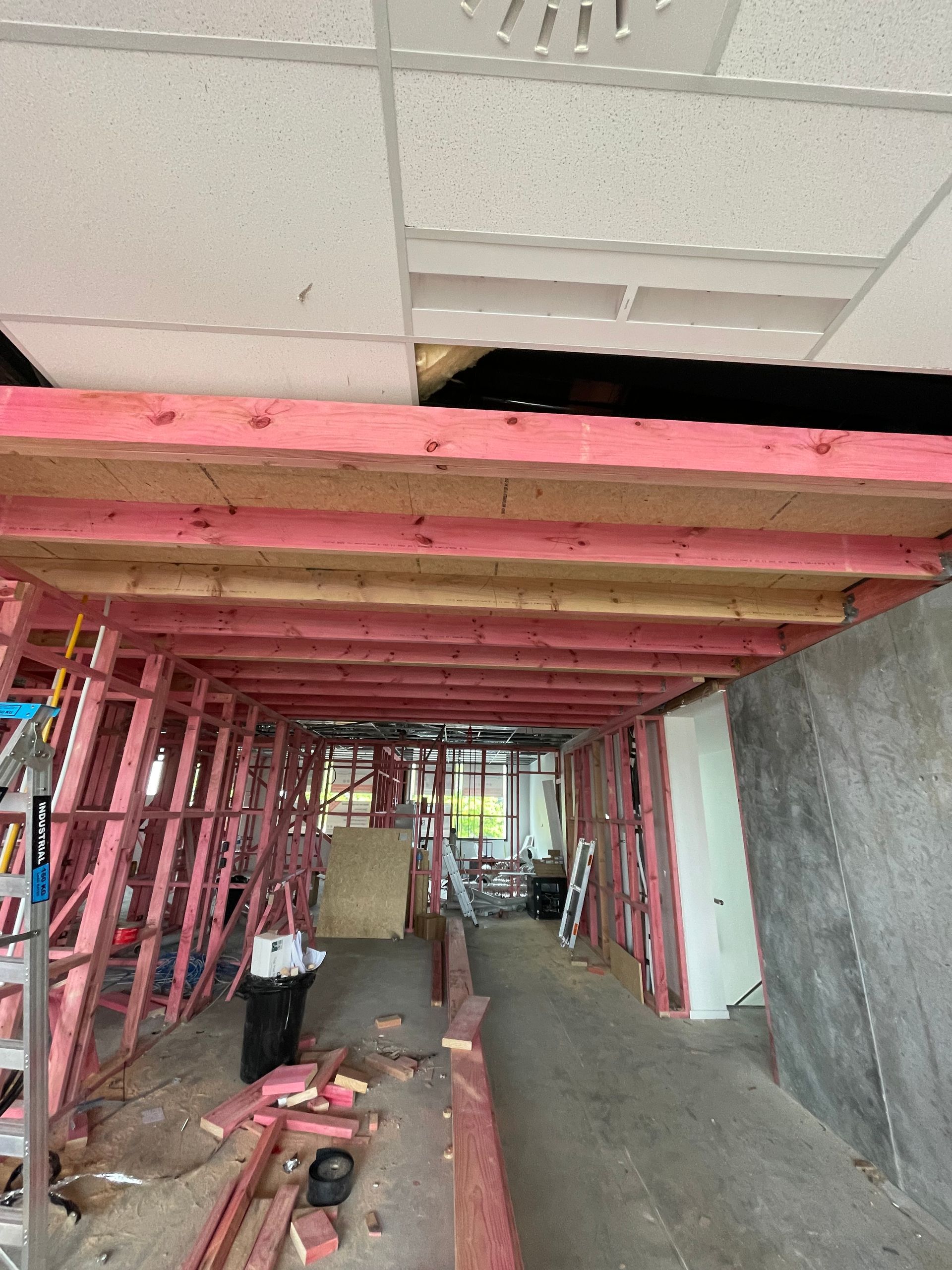A building under construction with pink beams and a white ceiling.