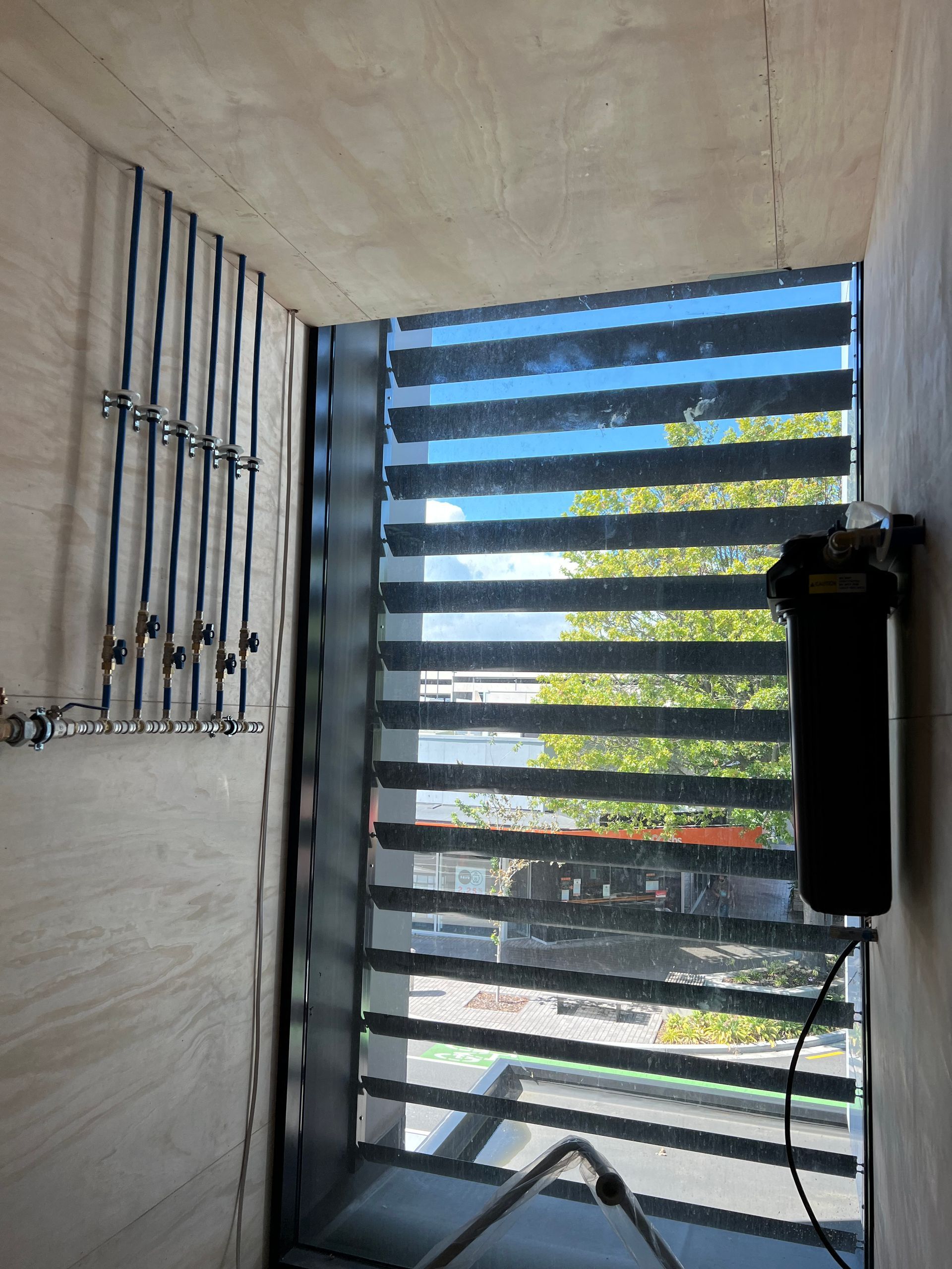 A room with a large window and a striped blind