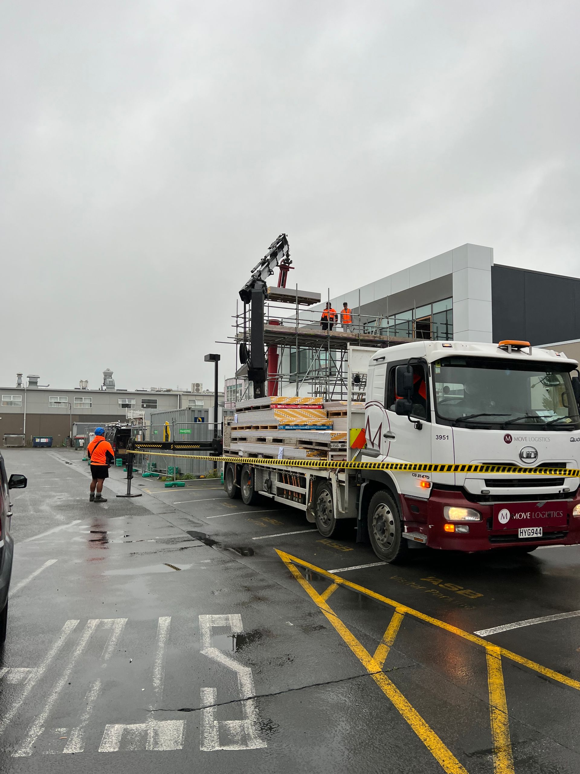 A truck with a crane on top of it is parked in a parking lot.
