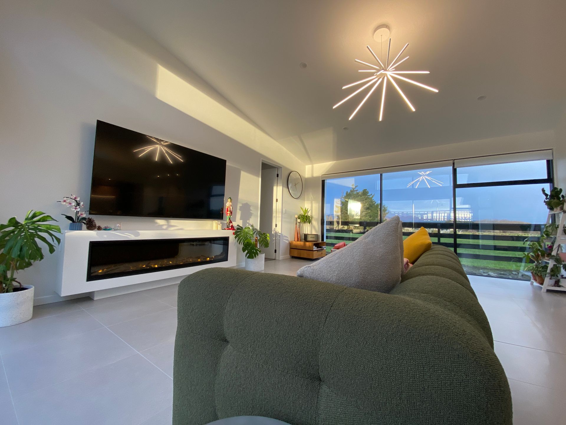 A living room with a green couch and a flat screen tv.