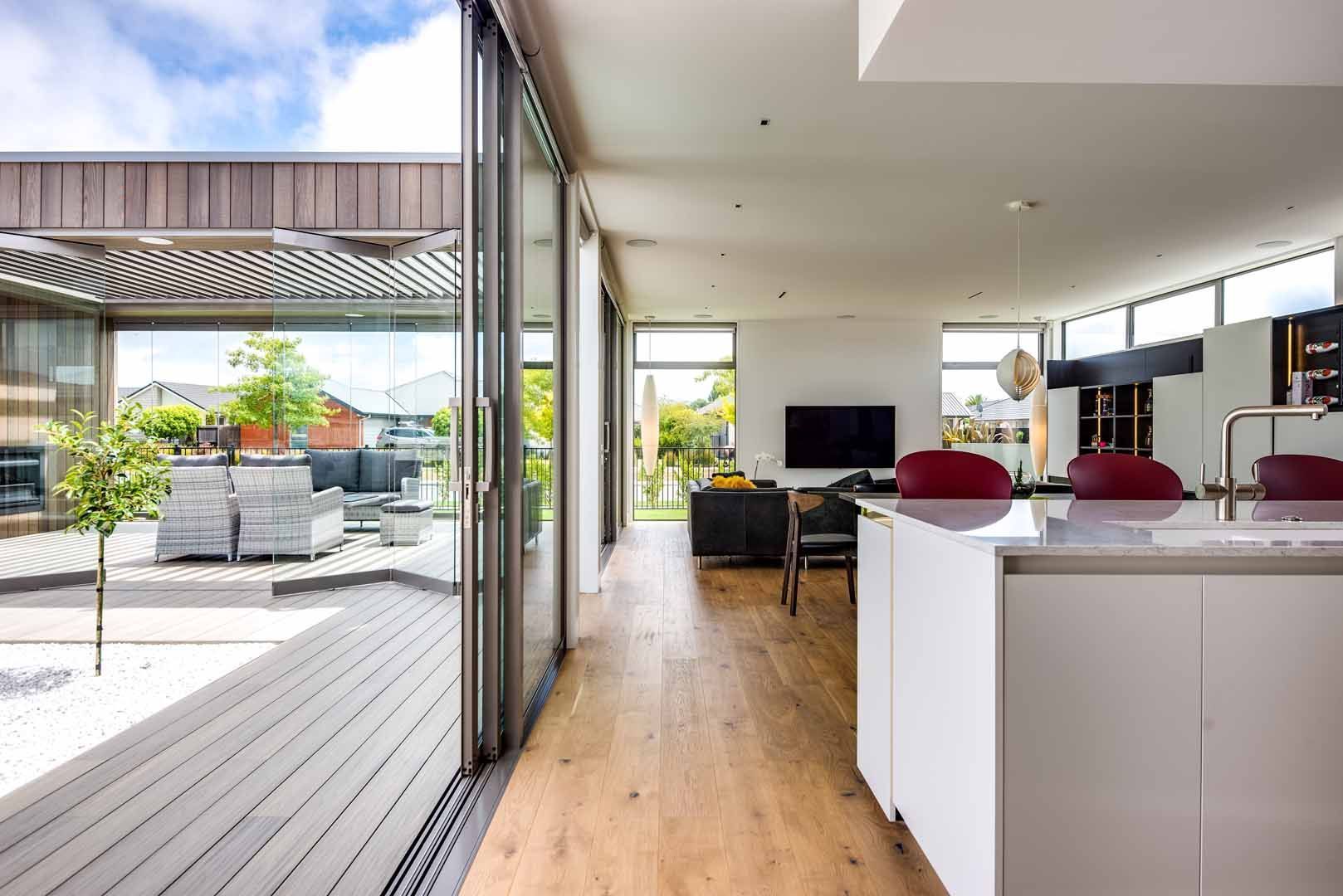 A kitchen and living room in a house with sliding glass doors