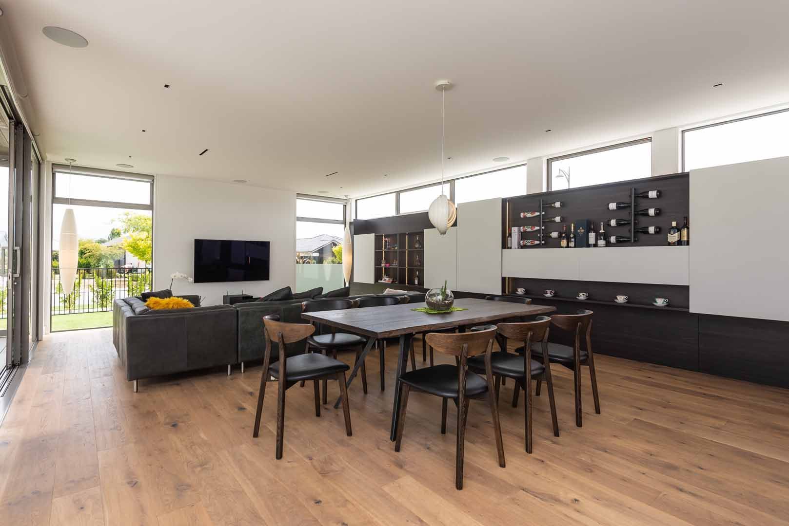 A living room with a dining table and chairs and a television.
