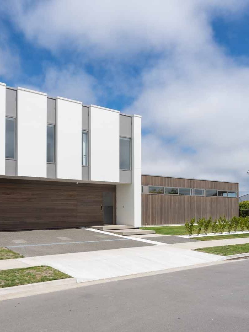 A large white building with a wooden garage door