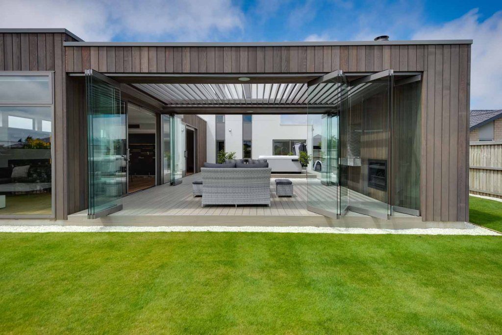 A house with a patio and a couch in the backyard.