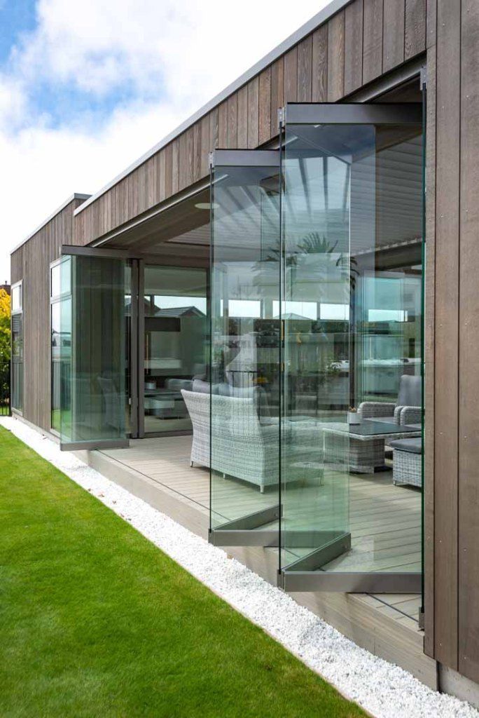 A house with a lot of windows and a lawn in front of it.