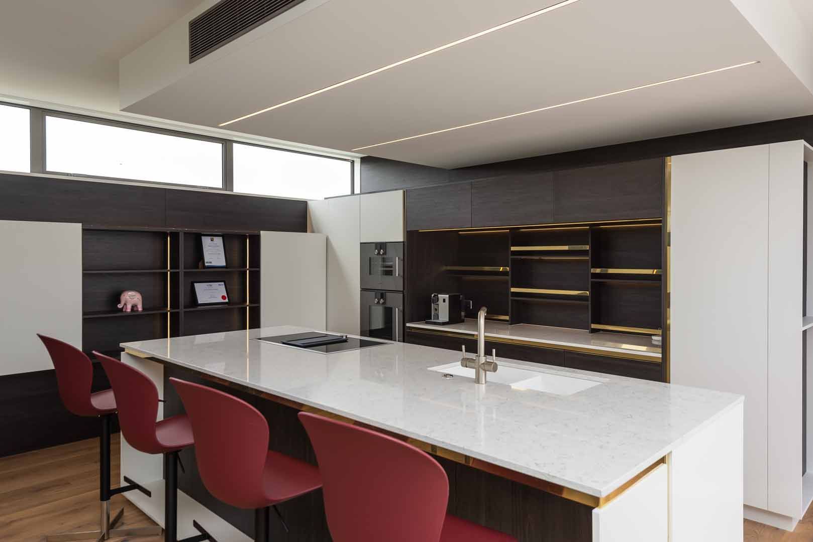 A kitchen with a large island and red chairs