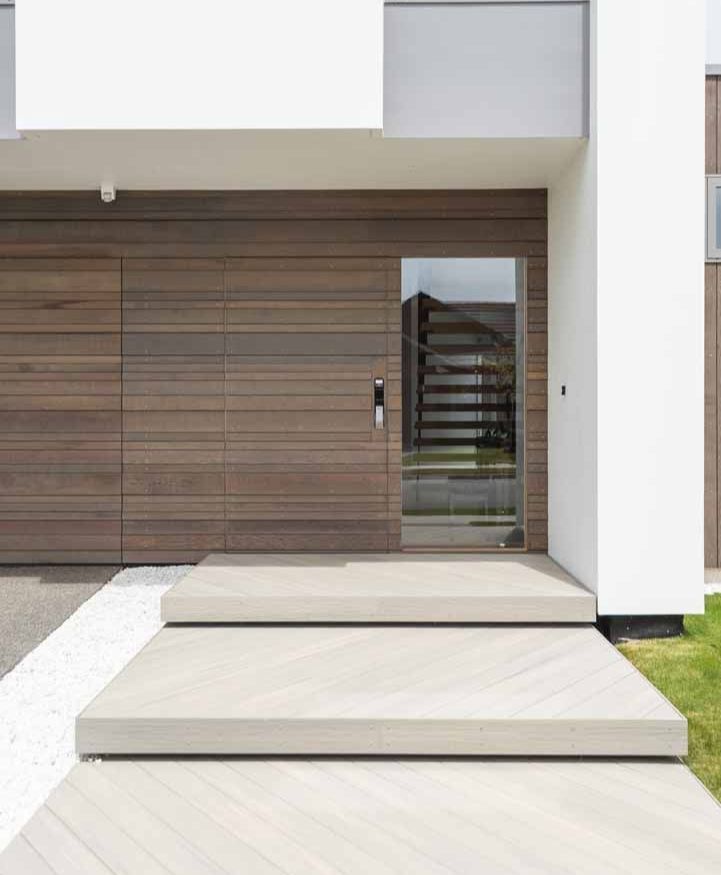 a modern house with a wooden door and a glass door