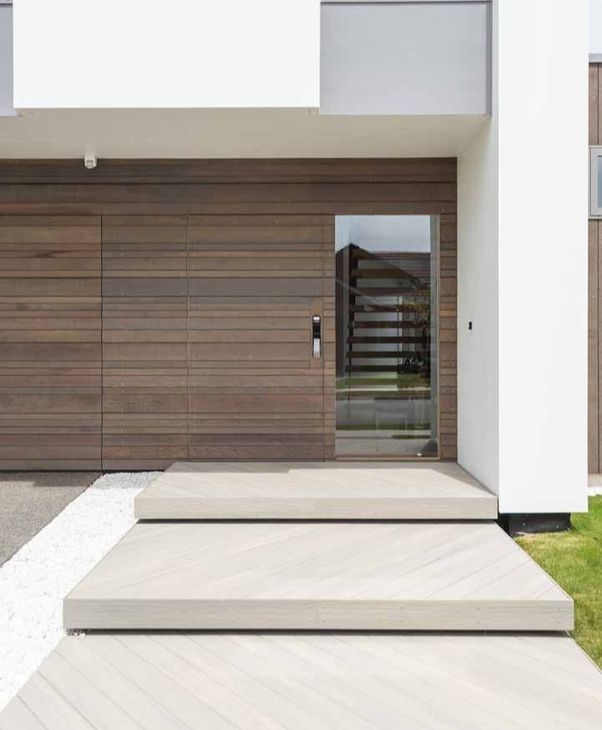a modern house with a wooden door and a glass door