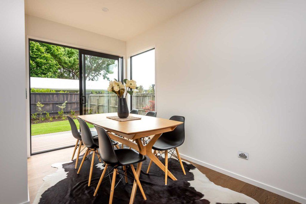 A dining room with a table and chairs and a cowhide rug.