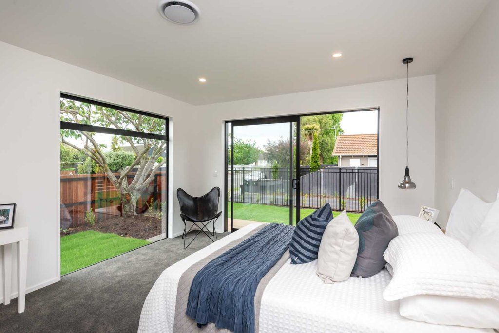 A bedroom with a large bed and sliding glass doors