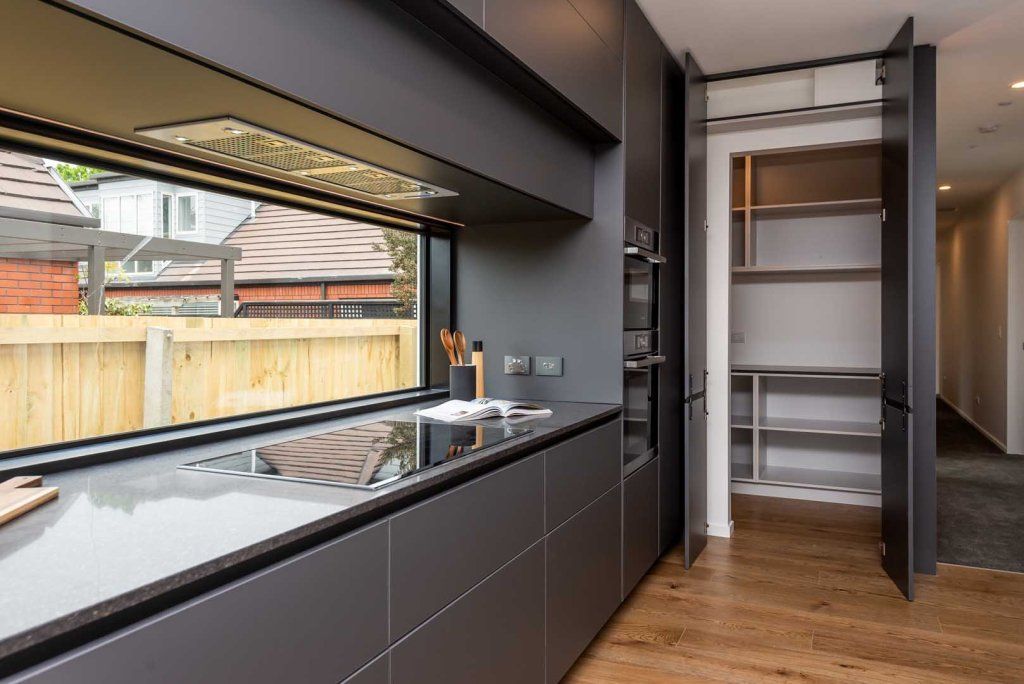 A kitchen with a large window and a stove top oven.