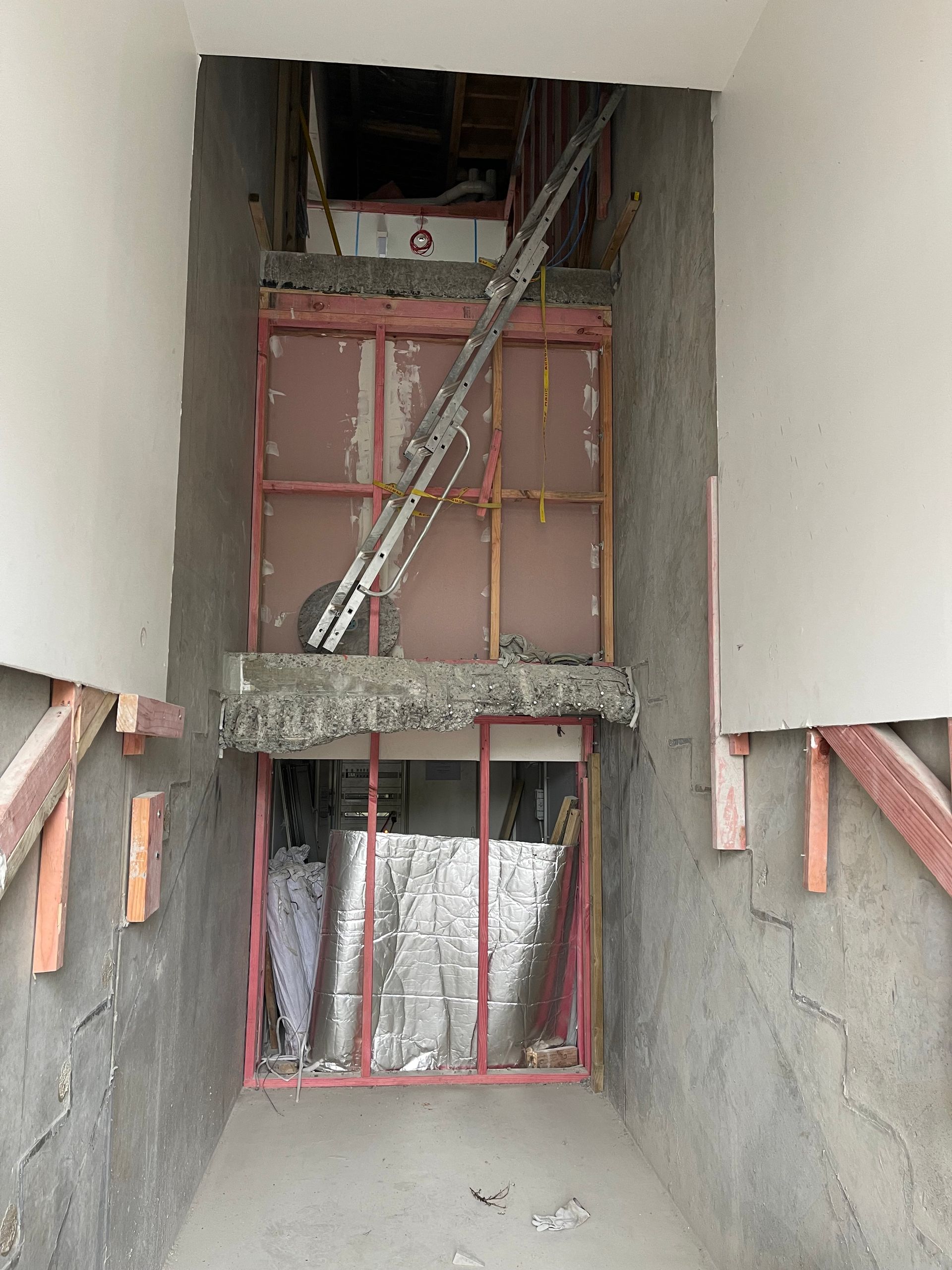A building under construction with a staircase going up to the ceiling.