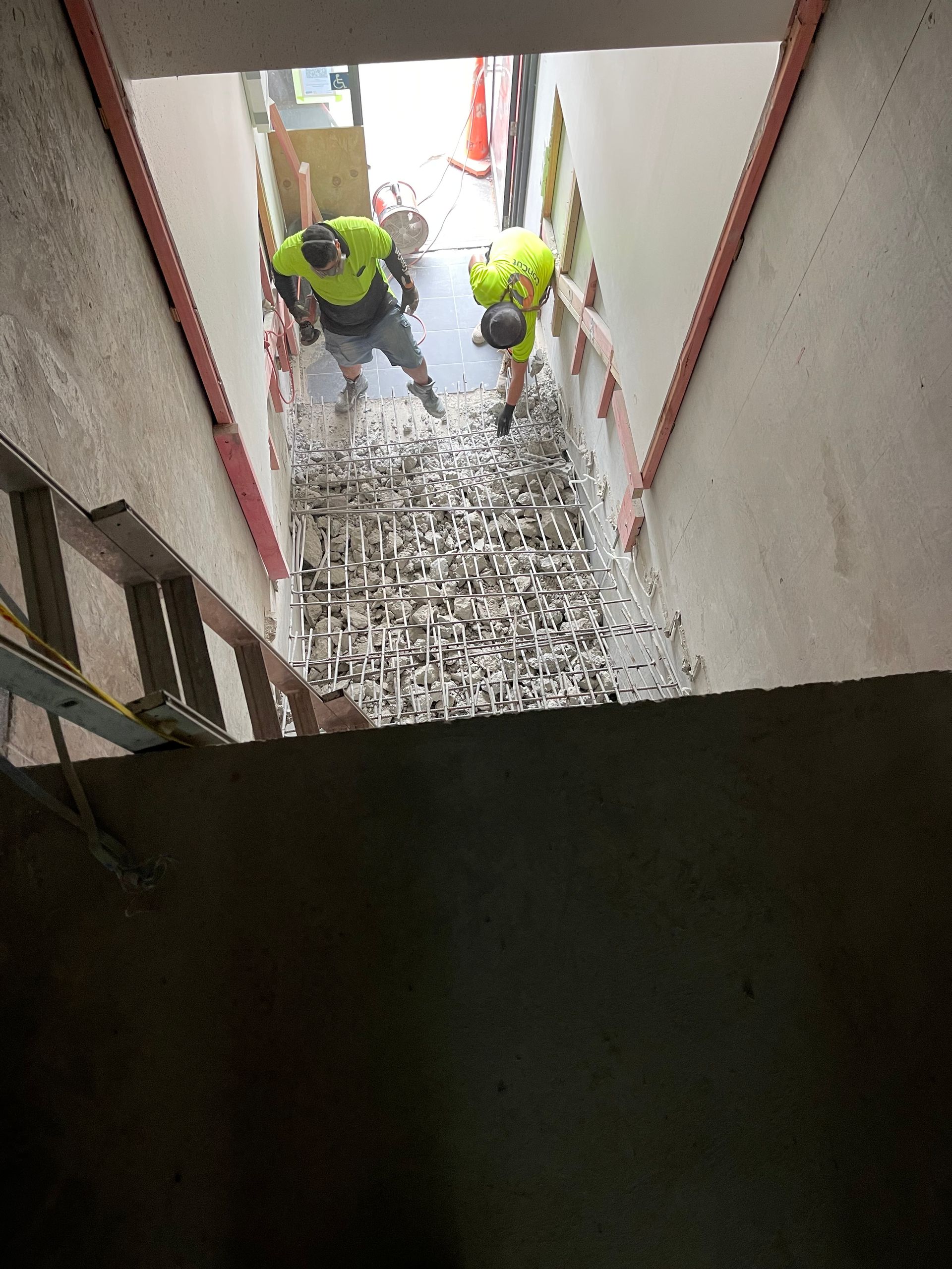 A couple of men are working on a staircase.