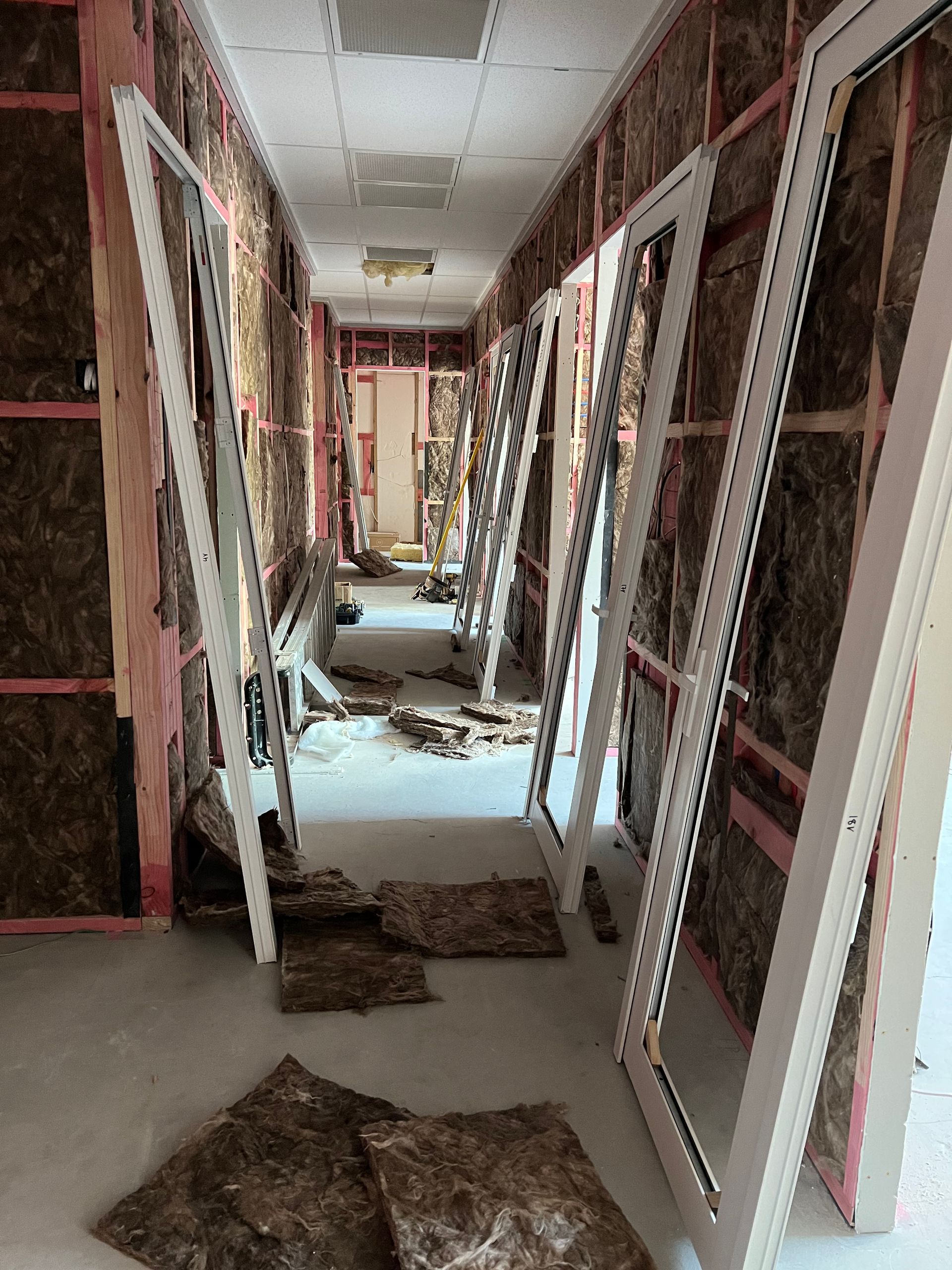 A long hallway with a lot of pieces of insulation on the floor.
