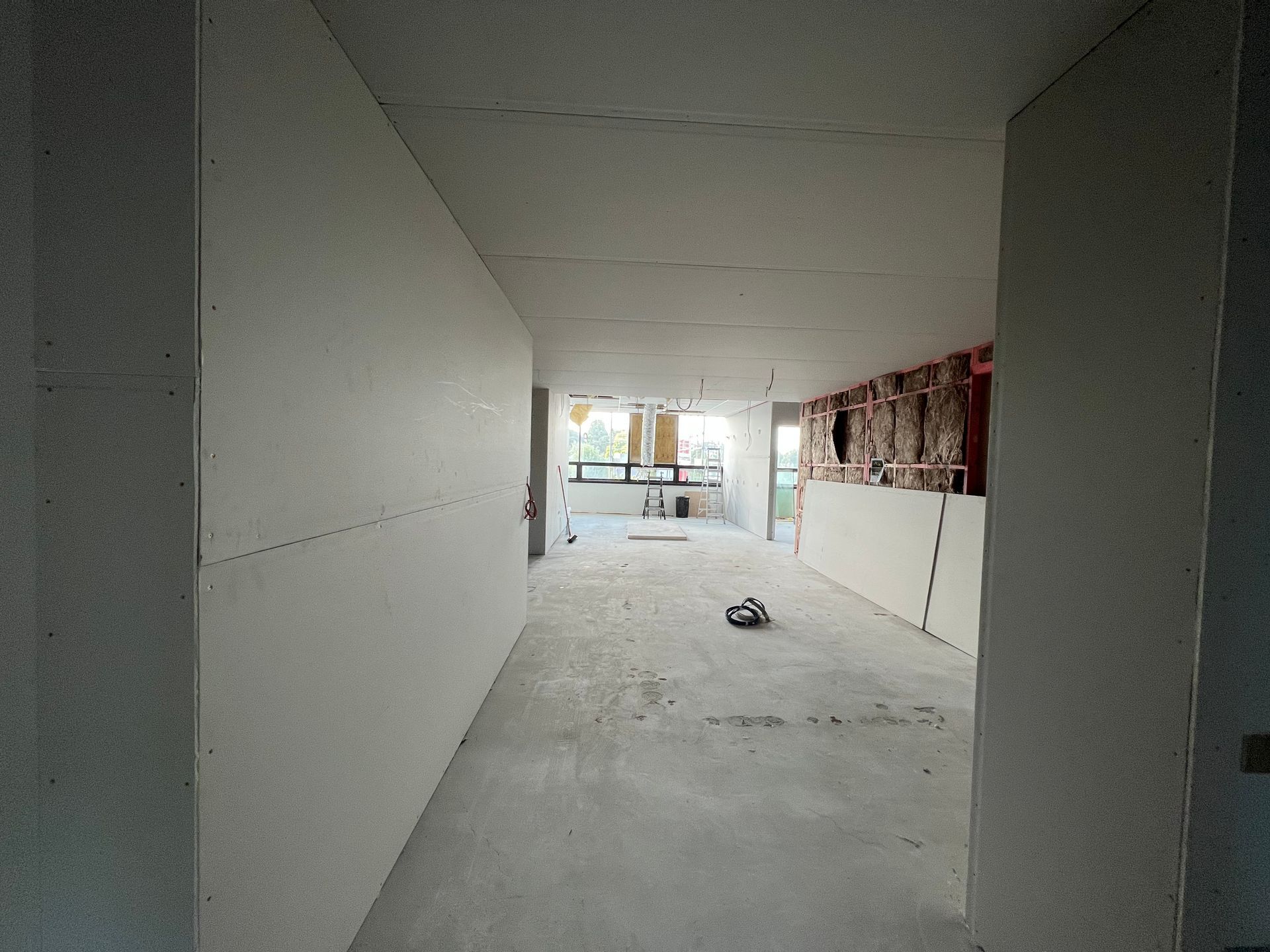 A large empty room with white walls and a concrete floor