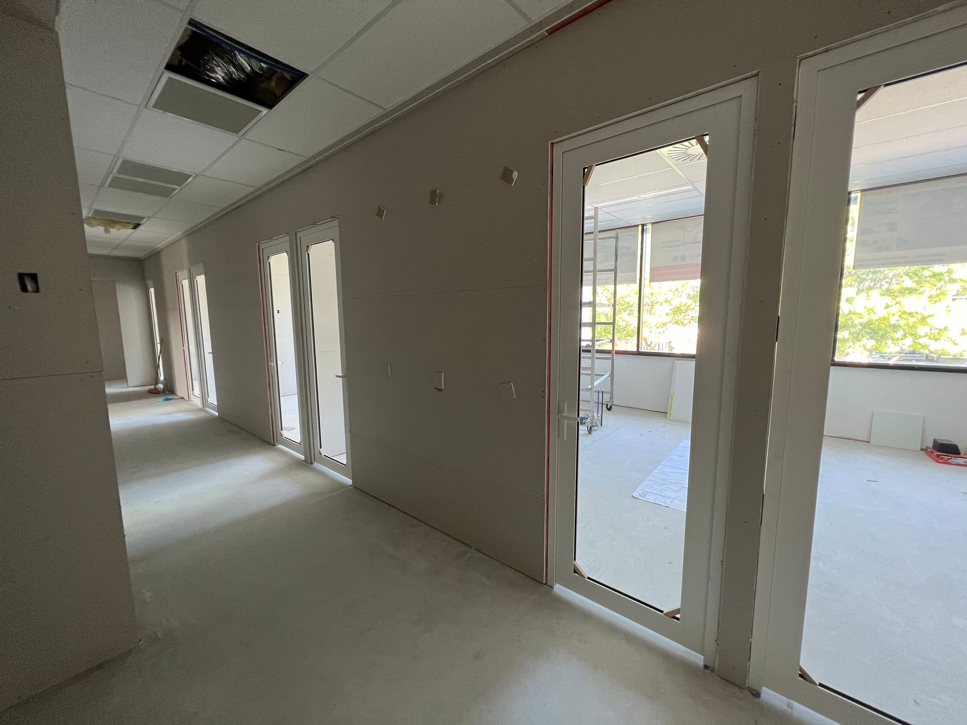 A long hallway with a lot of windows and doors.