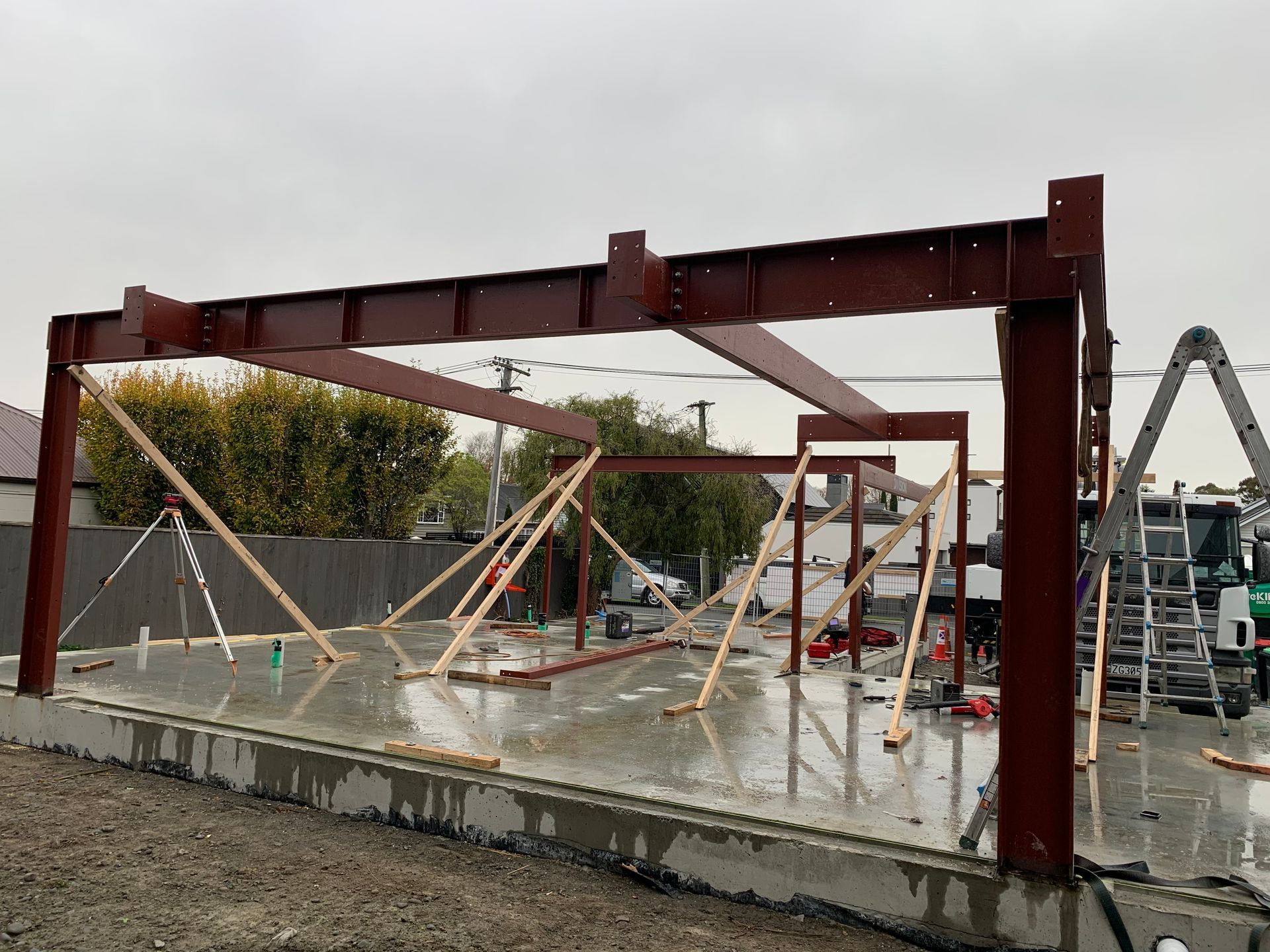 A large metal structure is being built on a concrete floor.
