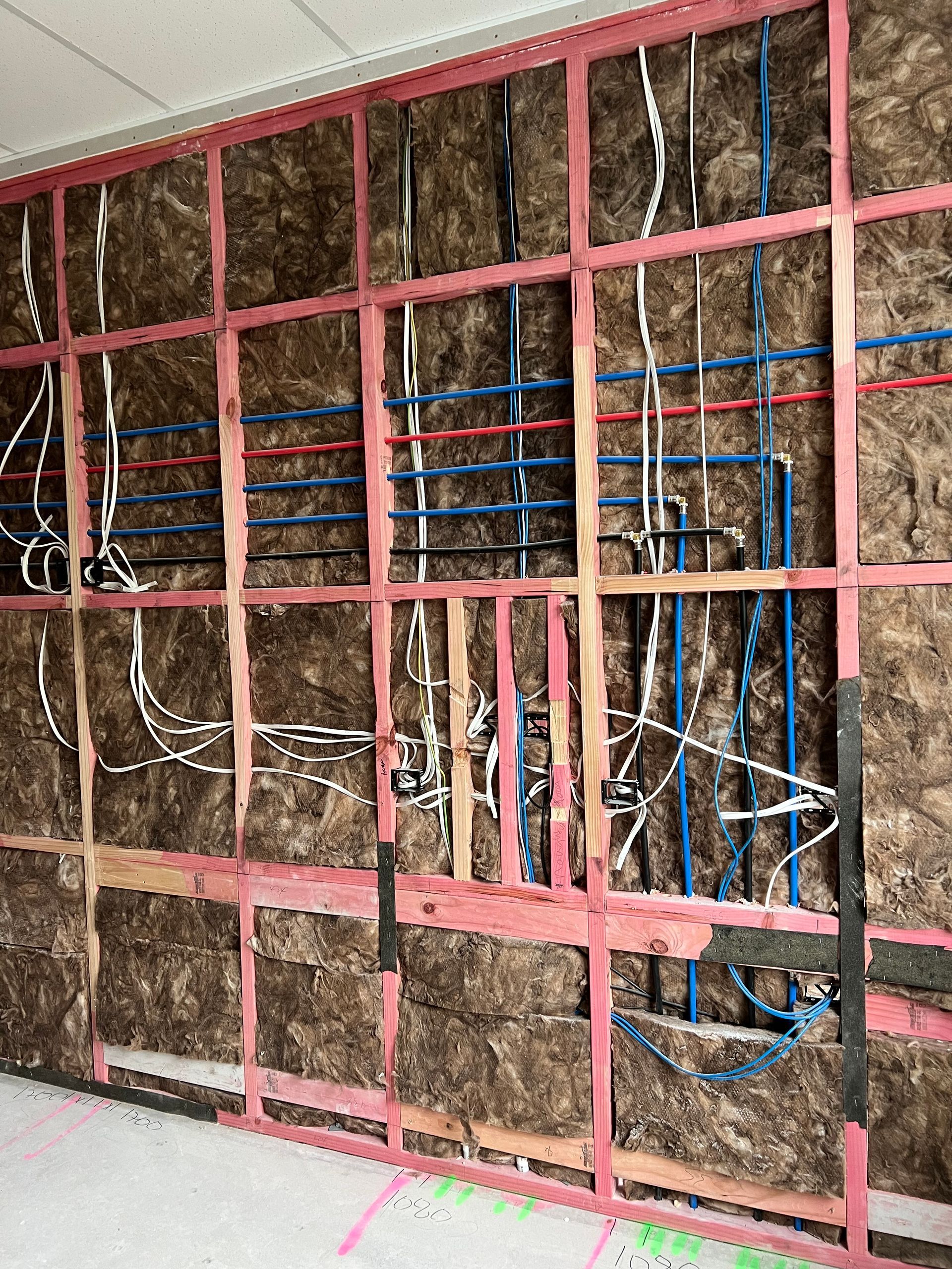 A wall with a lot of wires coming out of it.