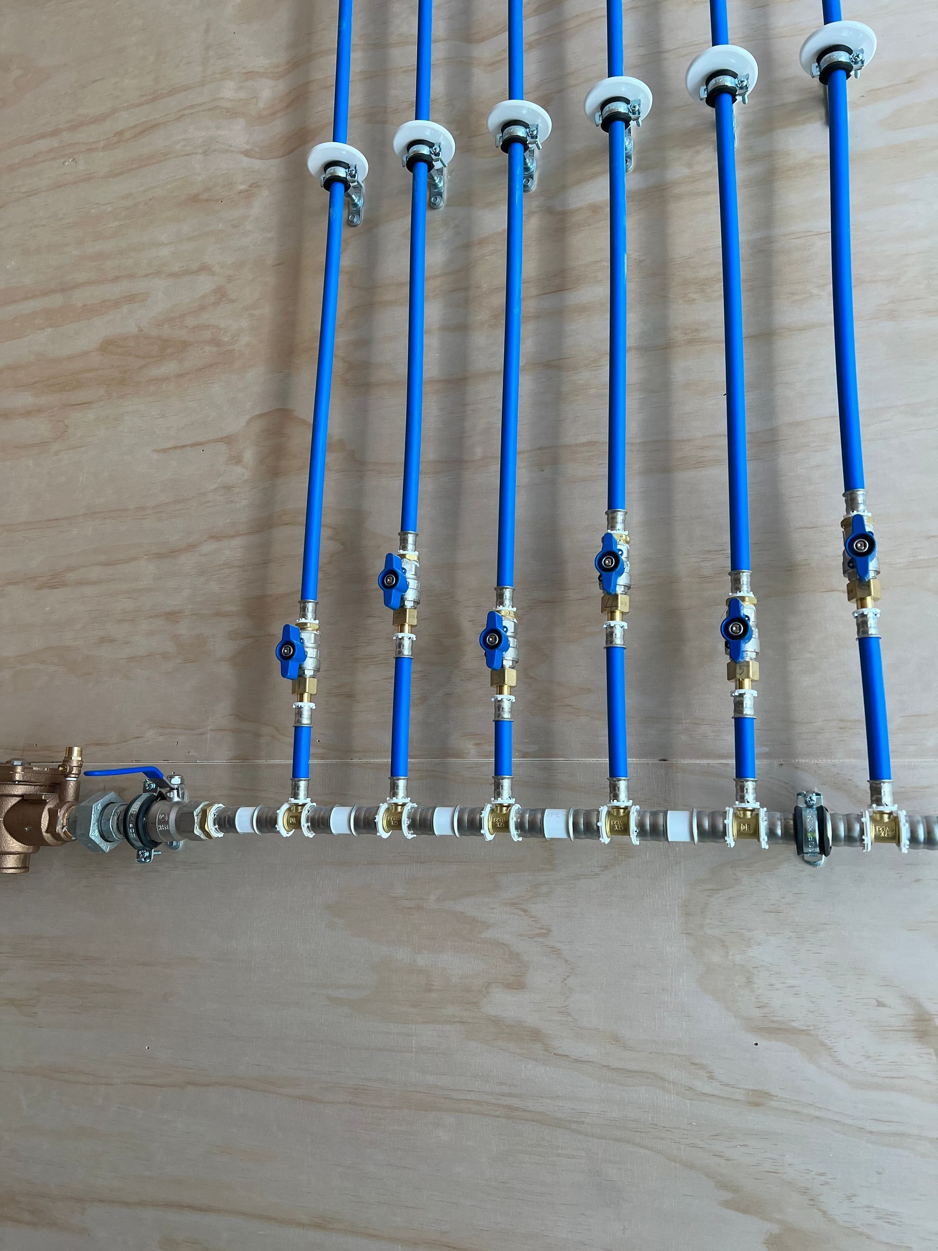 A bunch of blue pipes are lined up on a wooden surface