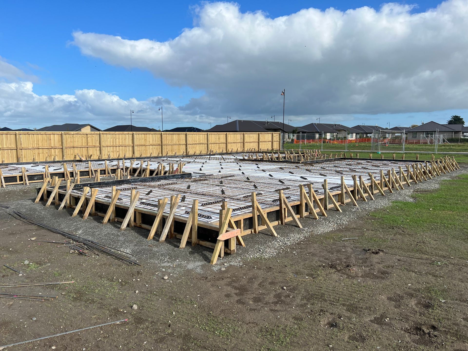 A construction site with a lot of wooden scaffolding in the dirt.