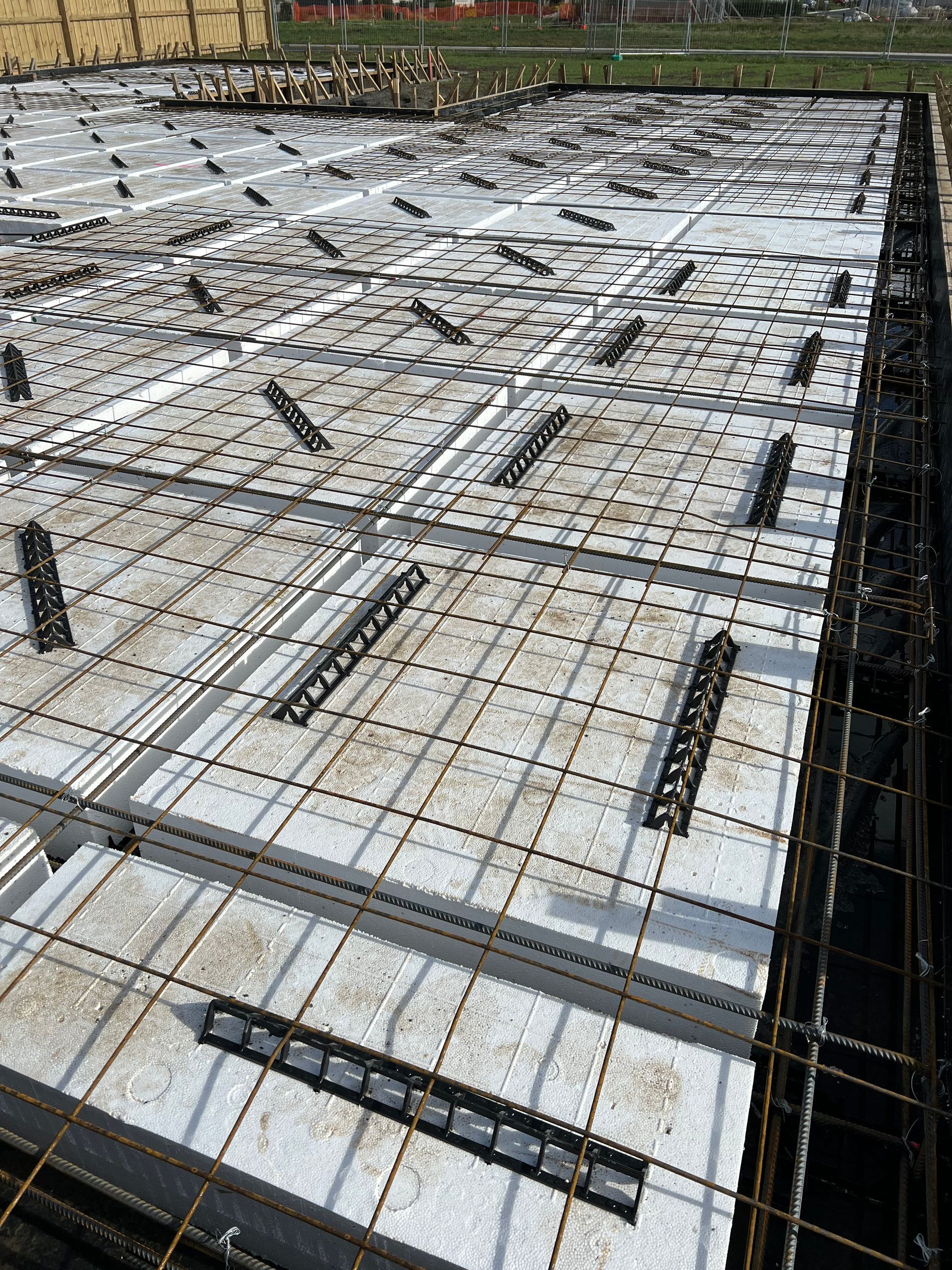 A concrete floor is being built on a construction site.